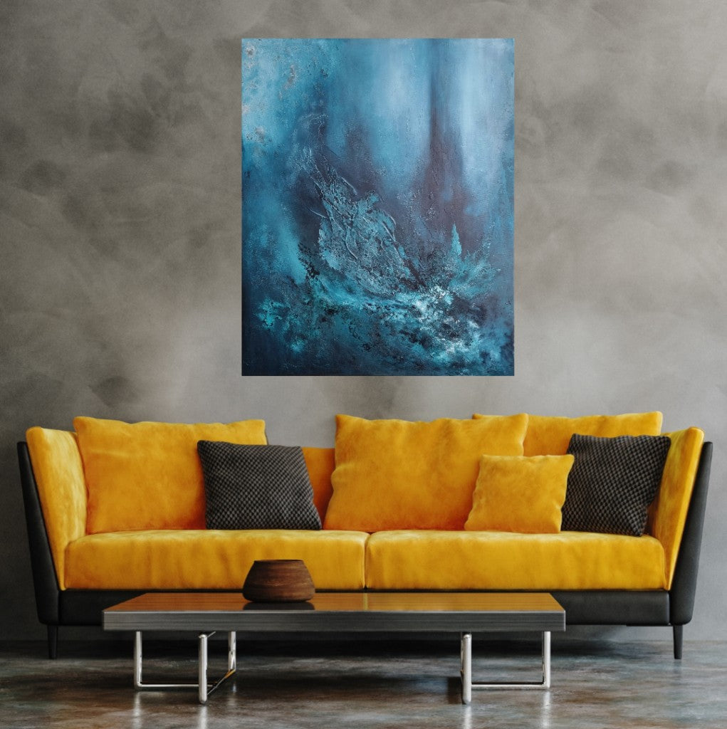 An abstract painting on a gray wall above a yellow sofa in a modern living room setting. The painting features various shades of blue with texture paste, created using acrylic paint on canvas. 