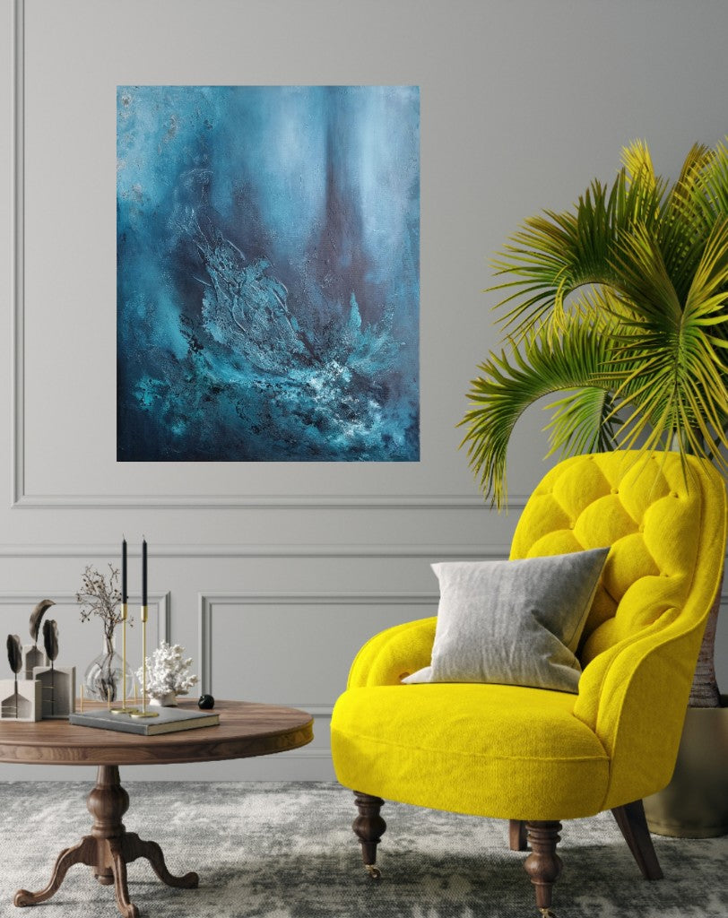 A large blue abstract painting is displayed in a stylish living room setting. The painting is positioned on a light gray wall above a yellow armchair, adding a pop of color to the space. A wooden coffee table with candles completes the interior decor.