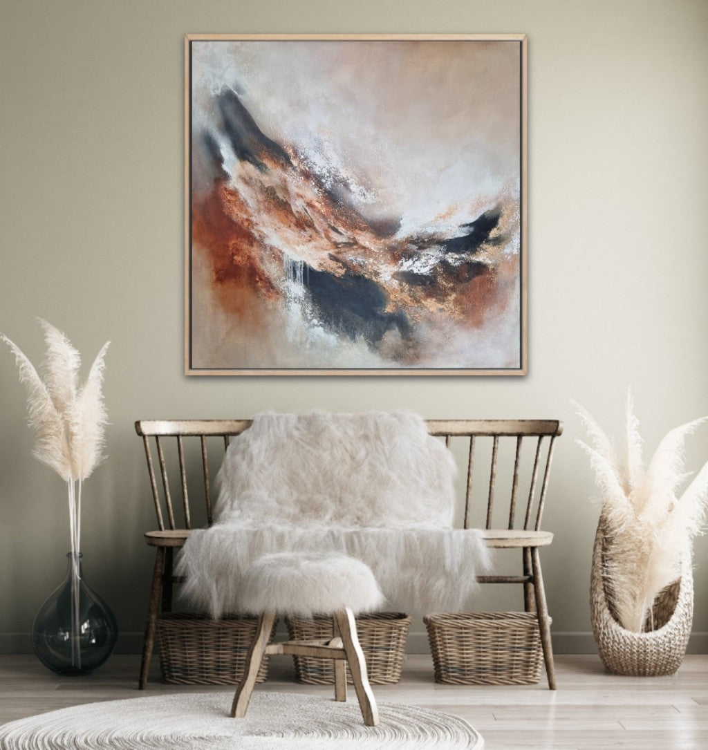 Large abstract acrylic painting with warm autumn colors. In a modern boho-style room with beige walls and wooden furniture and natural decoration materials.
